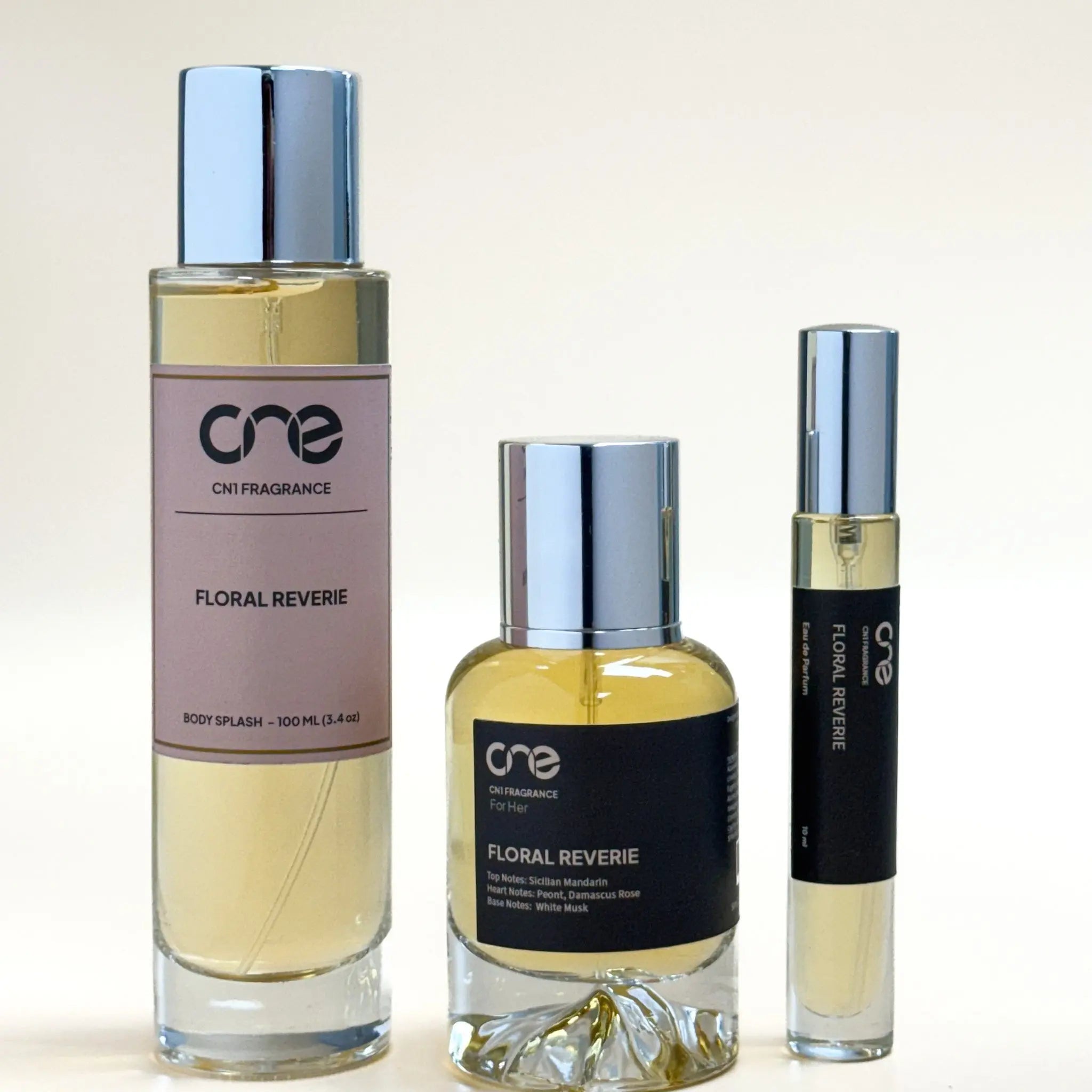 Three bottles of 'One' floral perfume on a light background